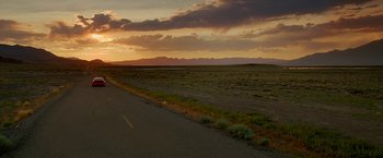 Movie still from “Need for Speed” (2014), directed by Scott Waugh – A sunset over a desert with a road in the foreground; Extreme Wide shot, Low angle