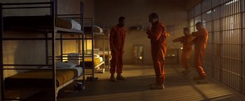 Movie still from “Need for Speed” (2014), directed by Scott Waugh – Two men in orange jumpsuits standing in a room with bunk beds; Wide shot, High angle