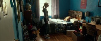 Movie still from “Nerve” (2016), directed by Henry Joost – A woman standing in front of a bed in a bedroom; Wide shot, High angle