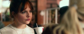 Movie still from “Nerve” (2016), directed by Henry Joost – A woman sitting at a table with a drink in her hand; Close Up shot, Over the shoulder angle