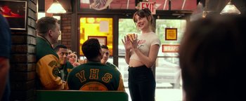 Movie still from “Nerve” (2016), directed by Henry Joost – A woman standing in front of a group of people; Medium shot, Over the shoulder angle