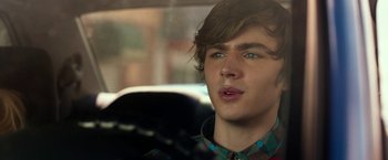 Movie still from “Nerve” (2016), directed by Henry Joost – A young man with long brown hair wearing a plaid shirt; Close Up shot, Over the shoulder angle