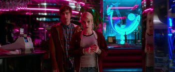 Movie still from “Nerve” (2016), directed by Henry Joost – A man and a woman standing next to each other in front of neon lights; Medium shot, Low angle