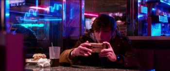 Movie still from “Nerve” (2016), directed by Henry Joost – A man taking a picture with a cell phone at a bar; Medium shot, Over the shoulder angle