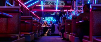Movie still from “Nerve” (2016), directed by Henry Joost – A woman sitting at a table on a bus; Wide shot, Low angle
