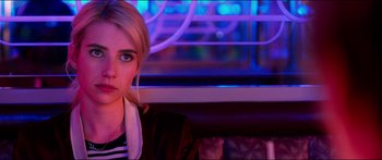 Movie still from “Nerve” (2016), directed by Henry Joost – A woman sitting on a bench in front of a window; Close Up shot, Over the shoulder angle