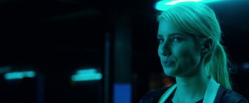 Movie still from “Nerve” (2016), directed by Henry Joost – A woman is standing in the dark with a neon light behind her; Close Up shot, Over the shoulder angle
