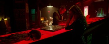 Movie still from “Nerve” (2016), directed by Henry Joost – A group of people sitting at a table in a bar; Medium shot, Over the shoulder angle