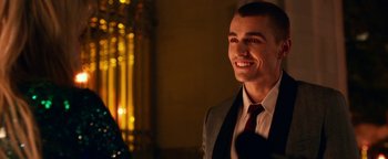 Movie still from “Nerve” (2016), directed by Henry Joost – A man in a suit and tie smiling for the camera; Close Up shot, Over the shoulder angle