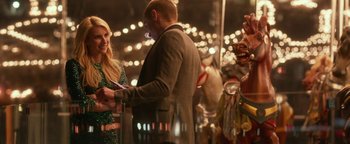 Movie still from “Nerve” (2016), directed by Henry Joost – A man and a woman standing next to each other in front of lights; Medium shot, Over the shoulder angle