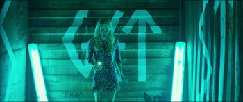Movie still from “Nerve” (2016), directed by Henry Joost – A woman standing on some steps holding a cell phone in her hand; Medium shot, Overhead angle