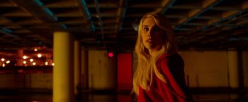 Movie still from “Nerve” (2016), directed by Henry Joost – A woman in a red shirt standing in a dark room; Medium shot, Over the shoulder angle