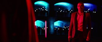 Movie still from “Nerve” (2016), directed by Henry Joost – A person standing in front of a stage with lights; Wide shot, Over the shoulder angle