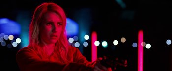 Movie still from “Nerve” (2016), directed by Henry Joost – A woman in a red jacket in a dark room; Close Up shot, Over the shoulder angle