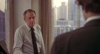 Movie still from “Network” (1976), directed by Sidney Lumet – An older man wearing a white dress shirt and a black tie; Medium shot, Over the shoulder angle