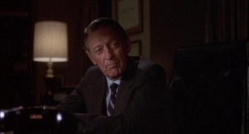 Movie still from “Network” (1976), directed by Sidney Lumet – An older man wearing a suit and tie sitting in front of a lamp; Close Up shot, Over the shoulder angle