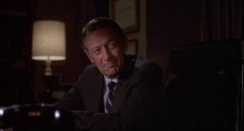 Movie still from “Network” (1976), directed by Sidney Lumet – An older man wearing a suit and tie sitting in front of a lamp; Close Up shot, Over the shoulder angle