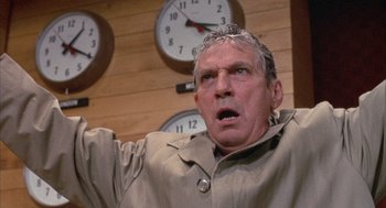 Movie still from “Network” (1976), directed by Sidney Lumet – An older man with a surprised look on his face in front of a wall of clocks; Close Up shot, Low angle