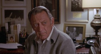 Movie still from “Network” (1976), directed by Sidney Lumet – An older man wearing a gray sweater in a room; Close Up shot, Over the shoulder angle