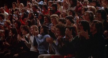 Movie still from “Network” (1976), directed by Sidney Lumet – A group of people sitting in a room clapping; Medium shot, Low angle