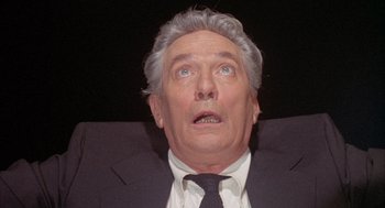 Movie still from “Network” (1976), directed by Sidney Lumet – An older man wearing a suit and tie looking up; Close Up shot, Low angle