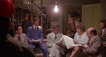 Movie still from “Network” (1976), directed by Sidney Lumet – A group of men and women sitting in a room; Wide shot, High angle
