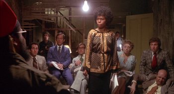 Movie still from “Network” (1976), directed by Sidney Lumet – A group of people sitting in a room; Medium shot, Low angle