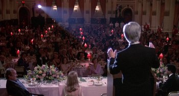 Movie still from “Network” (1976), directed by Sidney Lumet – A man standing in front of an audience at a banquet; Wide shot, Over the shoulder angle