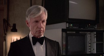 Movie still from “Network” (1976), directed by Sidney Lumet – An older man wearing a tuxedo in front of a television; Close Up shot, Low angle