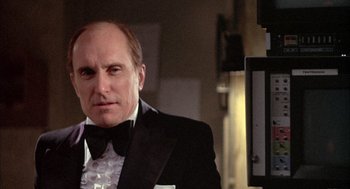 Movie still from “Network” (1976), directed by Sidney Lumet – A man in a tuxedo is looking at the camera; Close Up shot, Low angle