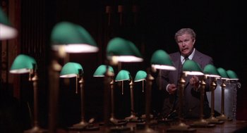 Movie still from “Network” (1976), directed by Sidney Lumet – A man standing in front of a bunch of green lamps; Medium shot, Low angle