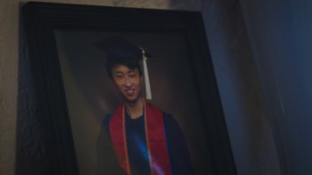 A portrait of a young man wearing a graduation cap and gown