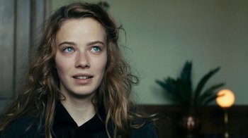 Movie still from “Never Look Away” (2018), directed by Florian Henckel von Donnersmarck – A person with long hair; Close Up shot, Over the shoulder angle