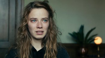 Movie still from “Never Look Away” (2018), directed by Florian Henckel von Donnersmarck – A woman with long brown hair and blue eyes; Close Up shot, Over the shoulder angle