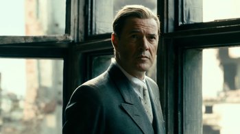 Movie still from “Never Look Away” (2018), directed by Florian Henckel von Donnersmarck – A person wearing a suit and tie; Close Up shot, Low angle