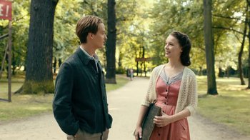 Movie still from “Never Look Away” (2018), directed by Florian Henckel von Donnersmarck – A man and a woman standing next to each other on a sidewalk; Medium shot, Over the shoulder angle