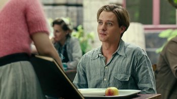 Movie still from “Never Look Away” (2018), directed by Florian Henckel von Donnersmarck – A man sitting at a table in front of a plate of food; Close Up shot, Over the shoulder angle