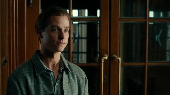 Movie still from “Never Look Away” (2018), directed by Florian Henckel von Donnersmarck – A man standing in front of a wooden door; Close Up shot, Over the shoulder angle