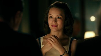 Movie still from “Never Look Away” (2018), directed by Florian Henckel von Donnersmarck – A young woman sitting in front of a man in a dark room; Close Up shot, Over the shoulder angle