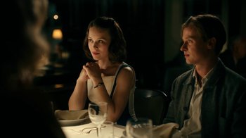 Movie still from “Never Look Away” (2018), directed by Florian Henckel von Donnersmarck – A woman sitting at a dinner table with a man; Medium shot, Over the shoulder angle
