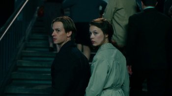 Movie still from “Never Look Away” (2018), directed by Florian Henckel von Donnersmarck – A man and a woman standing next to each other; Medium shot, Low angle