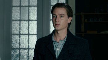 Movie still from “Never Look Away” (2018), directed by Florian Henckel von Donnersmarck – A young man in a black jacket is looking at the camera; Close Up shot, Over the shoulder angle
