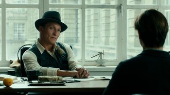 Movie still from “Never Look Away” (2018), directed by Florian Henckel von Donnersmarck – A man sitting at a table in front of a window; Medium shot, Over the shoulder angle