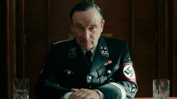 Movie still from “Never Look Away” (2018), directed by Florian Henckel von Donnersmarck – An older man in a military uniform sitting at a table; Close Up shot, Low angle