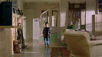 Movie still from “New Nightmare” (1994), directed by Wes Craven – A young boy standing in front of a spiral staircase; Wide shot, High angle
