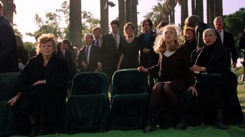 Movie still from “New Nightmare” (1994), directed by Wes Craven – A group of people sitting in chairs in the grass; Wide shot, Over the shoulder angle