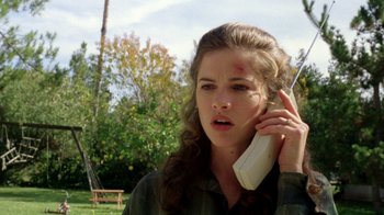 Movie still from “New Nightmare” (1994), directed by Wes Craven – A woman holding a phone up to her ear; Close Up shot, Low angle