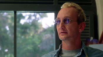 Movie still from “New Nightmare” (1994), directed by Wes Craven – A person wearing glasses; Close Up shot, Low angle