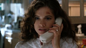 Movie still from “New Nightmare” (1994), directed by Wes Craven – A woman holding a phone up to her ear; Close Up shot, Low angle