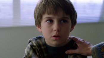 Movie still from “New Nightmare” (1994), directed by Wes Craven – A young boy is looking into the distance; Close Up shot, Over the shoulder angle